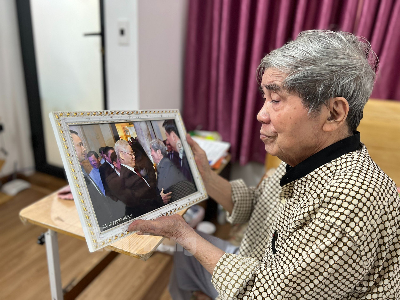 Nhà giáo Hà Minh Đức gìn giữ cẩn thận tấm ảnh chụp chung với Tổng Bí thư Nguyễn Phú Trọng. Ảnh: Nguyên Khánh.