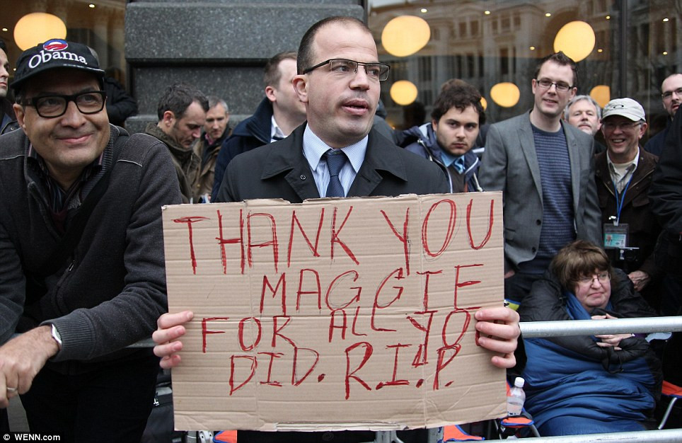 Người dân Anh đứng chờ xe rước linh cữu cựu thủ tướng Anh đi qua, trên tay cầm tấm biển có nội dung cảm ơn bà Margret Thatcher