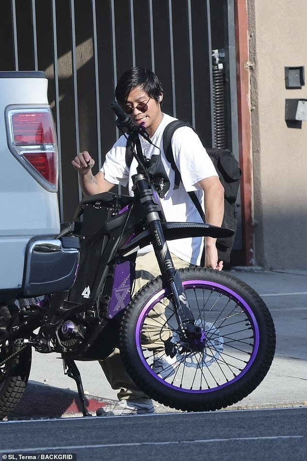 Pax Thiên ngồi bắt chân một bên, không đội mũ bảo hiểm khi lái xe đạp điện vào ngày 11/7. Ảnh: BackGrid.