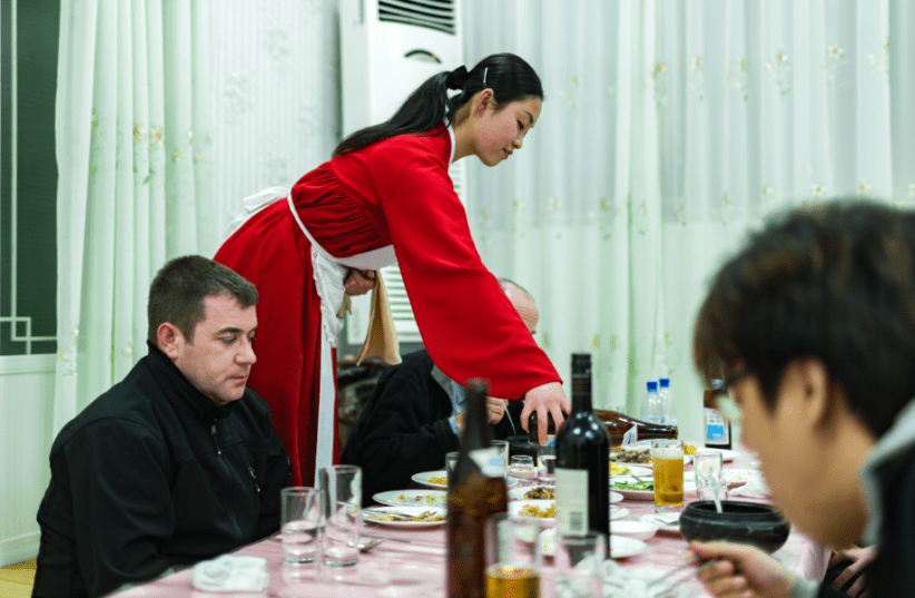 Một người Triều Tiên phục vụ bia cho khách du lịch nước ngoài tại khách sạn Kaesong Folk. Nguồn: Shutterstock. Một người Triều Tiên phục vụ bia cho khách du lịch nước ngoài tại khách sạn Kaesong Folk. Nguồn: Shutterstock.