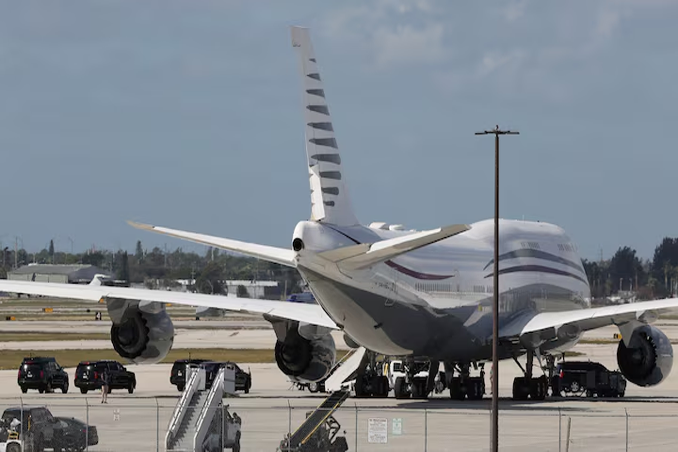 Đoàn xe hộ tống Tổng thống Mỹ Donald Trump đỗ cạnh chiếc Boeing 747-8 có 12 năm tuổi tại sân bay Palm Beach. Ảnh: Reuters. Đoàn xe hộ tống Tổng thống Mỹ Donald Trump đỗ cạnh chiếc Boeing 747-8 có 12 năm tuổi tại sân bay Palm Beach. Ảnh: Reuters.