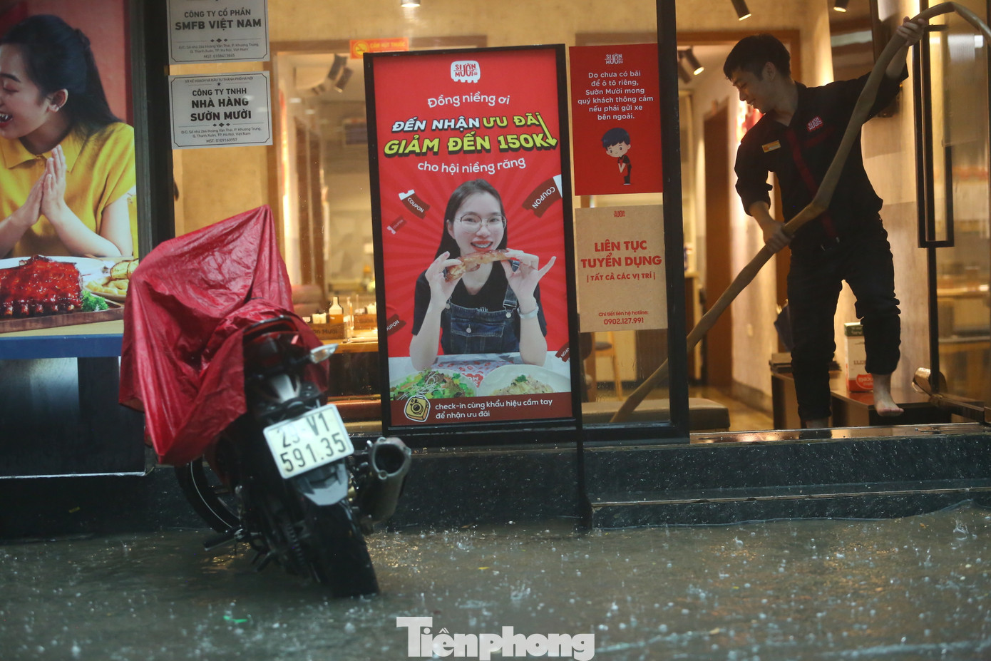 Một cửa hàng dùng vòi bơm nước khi phố biến thành sông.