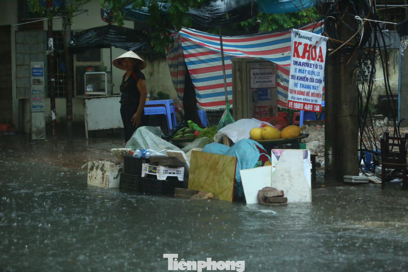 Một sạp hoa quả đứng giữa biển nước.