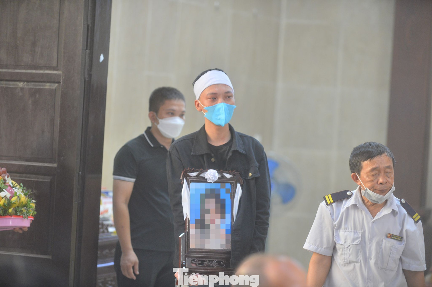 Anh trai Dương Thị D. cầm di ảnh em, nghẹn ngào gạt nước mắt.