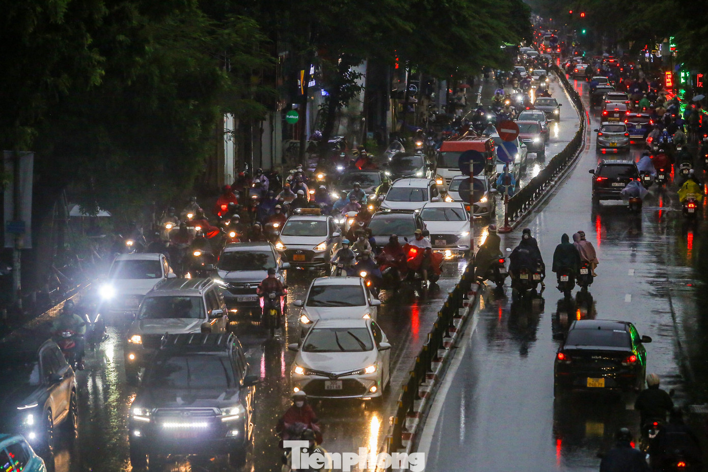 Hình ảnh ghi nhận trên phố Tây Sơn lúc 18h30, phương tiện di chuyển vẫn dày đặc dưới cơn mưa tầm tã.