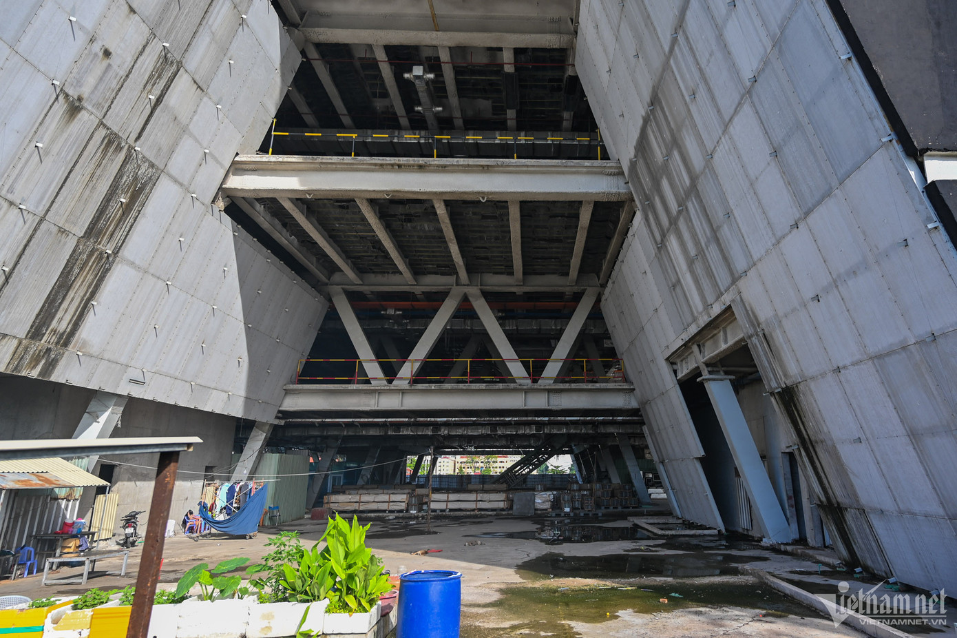 Bên trong công trình là nơi nghỉ ngơi của các công nhân làm việc gần đó. Hiện mỗi tầng mới làm xong hệ thống đường ống trên trần. Tường và cột chưa được sơn trát, sàn đọng nước.