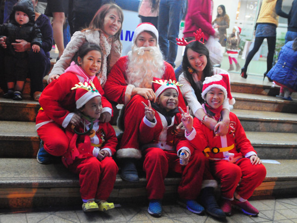 Các em nhỏ được bố mẹ bồng bế, nâng niu trong những bộ trang phục ông già Noel thật ngộ nghĩnh