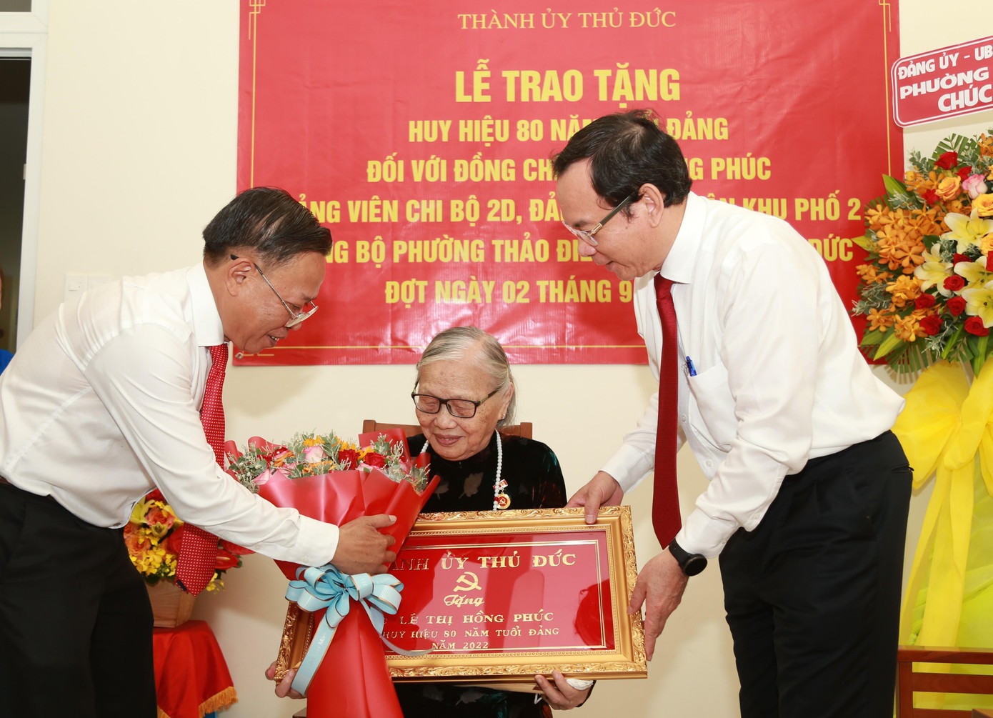 Bí thư Thành ủy TPHCM Nguyễn Văn Nên và Bí thư Thành ủy Thủ Đức Nguyễn Hữu Hiệp trao hoa và bức khánh chúc mừng bà.