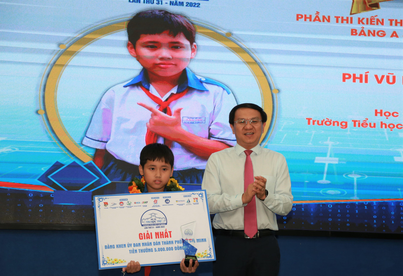 Giám đốc Sở Thông tin và Truyền thông TPHCM Lâm Đình Thắng trao giải Nhất bảng A (khối Tiểu học) cho em Phí Vũ Nhật Quang (Trường Tiểu học Tân Phú, huyện Củ Chi).