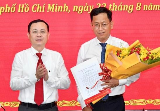 Phó Bí thư Thành ủy TPHCM Nguyễn Văn Hiếu trao quyết định cho ông Trần Quốc Trung. Ảnh: SGGP.