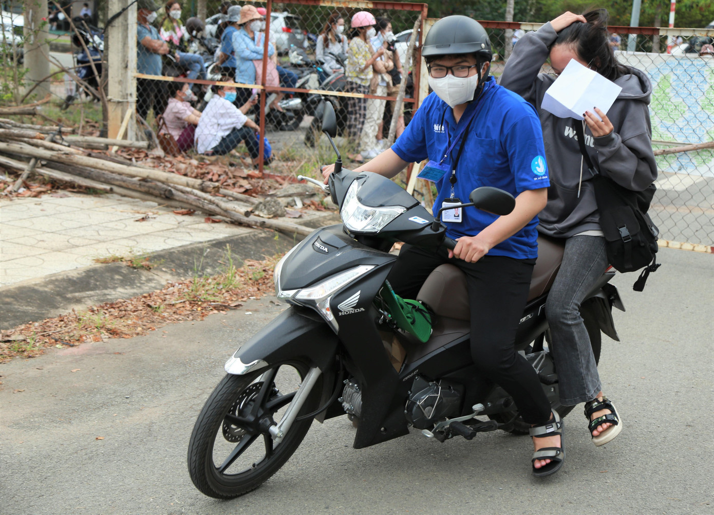 Với những thí sinh đến sát giờ thi, tình nguyện viên nhà trường khẩn trương dùng xe máy chở các em vào đến tận khu vực phòng thi