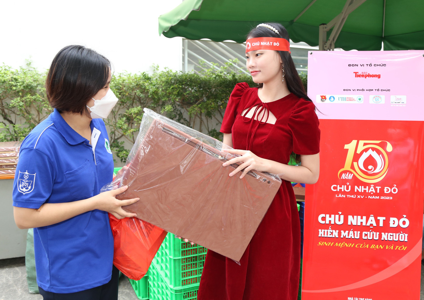 Lê Minh Anh cùng Nguyễn Lê Hoàng Linh (phải) đến chương trình sớm phụ Ban tổ chức phát quà cho các bạn sinh viên tham gia hiến máu.