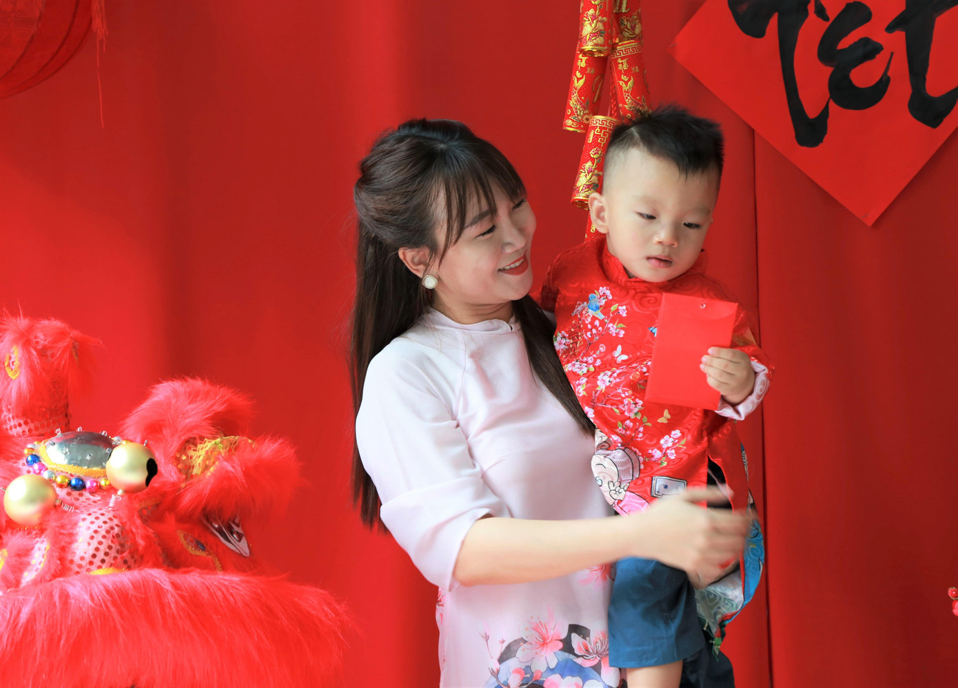 Em nhỏ cùng người thân mặc đồ Tết đi chụp hình.