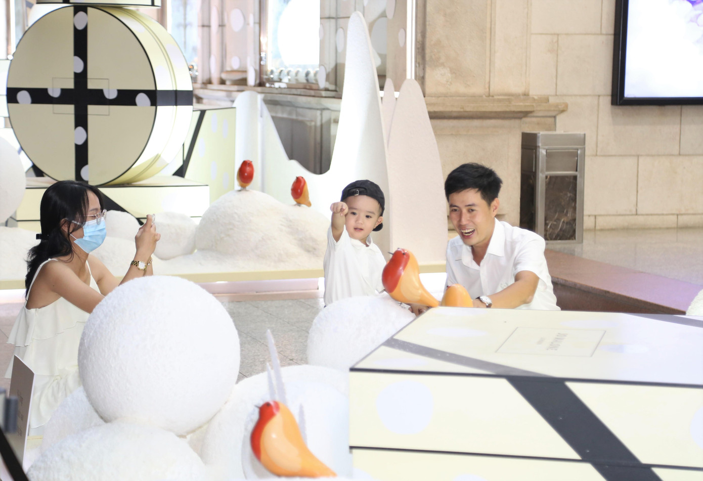 Cả gia đình trẻ diện "cây đồ trắng" đến chụp ảnh cùng các hình nộm ông già tuyết và tiểu cảnh Noel giữa Sài thành.