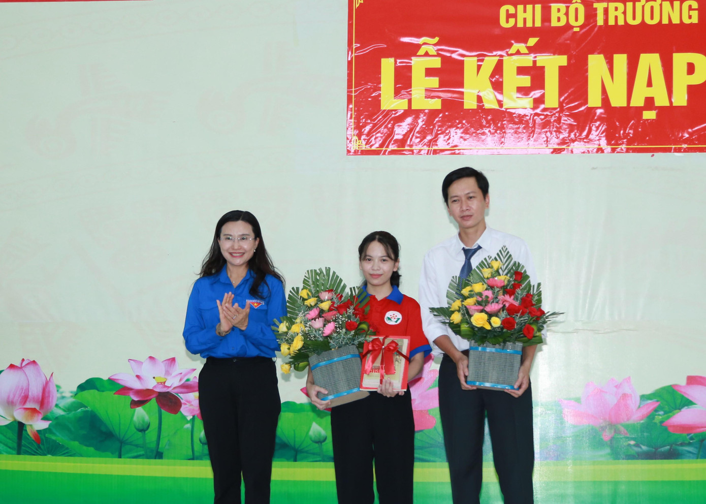 Chị Nguyễn Phạm Duy Trang, Bí thư Trung ương Đoàn, Chủ tịch Hội đồng Đội Trung ương tặng hoa chúc mừng thầy giáo Đào Công Toàn và học sinh Nguyễn Thùy Trang - Ảnh: Ngô Tùng