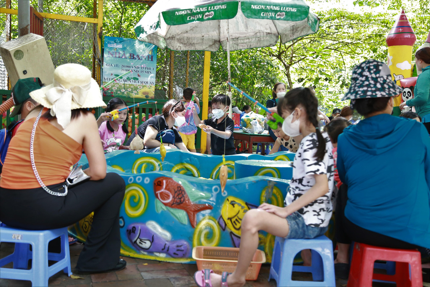 Các em nhỏ chơi câu cá trong công viên thú.