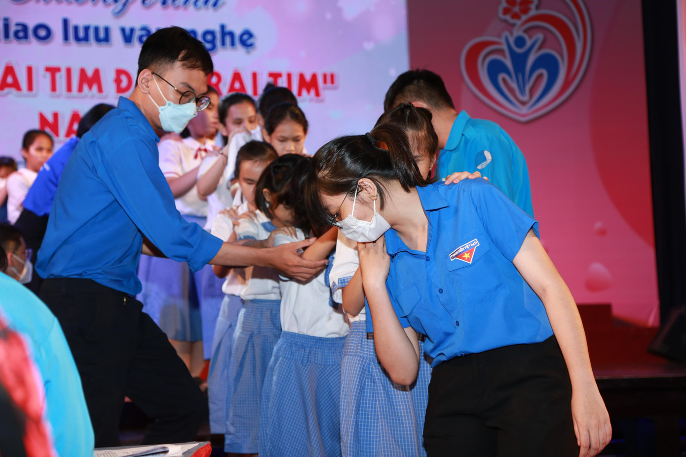 Các bạn đoàn viên thanh niên hỗ trợ các em học sinh khiếm khuyết đi lại.