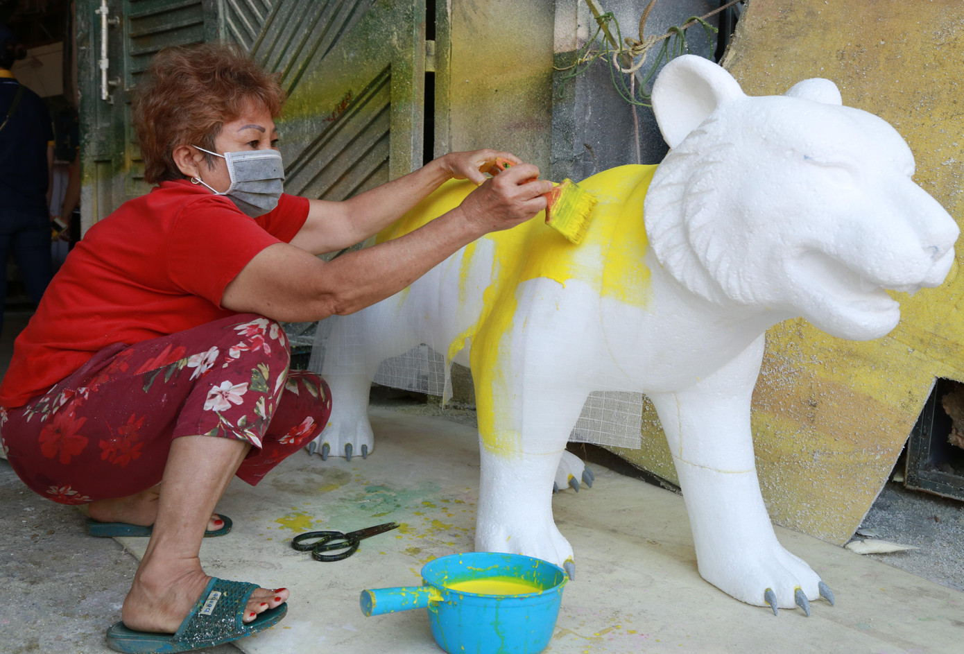 Bà Nguyễn Thị Cơ - người nhiều năm liền tham gia làm linh vật đường hoa - đang thực hiện bước dán phủ lớp vải mùng lên vật thể để tạo độ cứng cáp cho linh vật. Tiếp đó, bà Cơ sẽ sơn phủ bên ngoài linh vật.