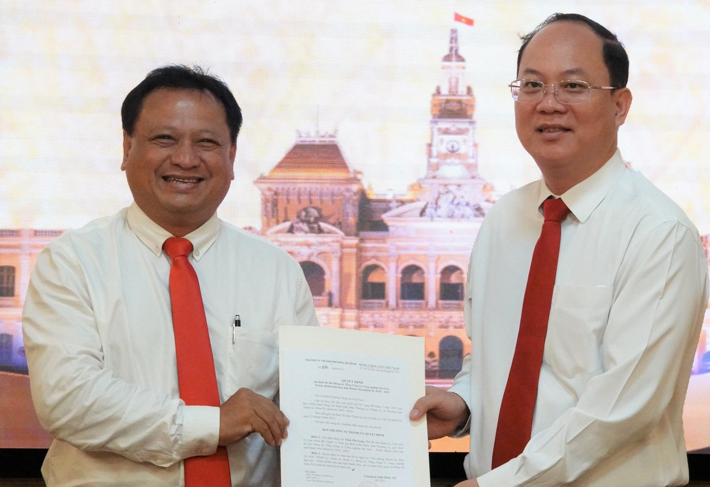 Phó Bí thư Thành ủy TPHCM Nguyễn Hồ Hải trao quyết định cho ông Trần Phi Long (bìa trái). Ảnh: SGGP.