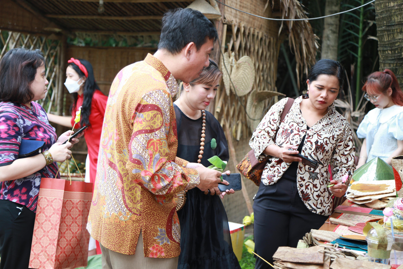 Vị khách quốc tế tham quan một gian hàng sản phẩm lưu niệm được làm bằng lá sen.