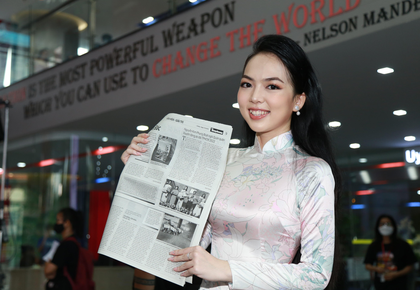 Vốn có sở trường và yêu thích học môn Hóa cũng như được sự ủng hộ từ gia đình, Kim Phụng đã chọn theo đuổi ngành Dược ở môi trường đại học với mong muốn trở thành dược sĩ. “Một bên là đam mê và một bên là sự nghiệp, Phụng sẽ cố gắng thu xếp, cân bằng cả hai”, nữ sinh chia sẻ. Trong ảnh: Kim Phụng vui mừng xem bản tin về đêm Chung kết cuộc thi Duyên dáng áo dài TPHCM 2022, được đăng tải trên ấn phẩm Tiền Phong nhật báo.