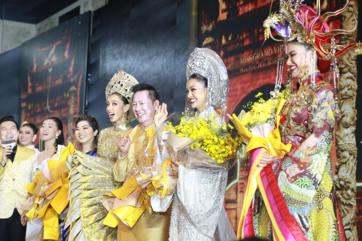 Ông Nawat cùng Hoa hậu Thùy Tiên và Top 10 Miss Grand Thailand 2022 trên sân khấu khởi động Miss Grand Vietnam 2022. Tại sự kiện mở màn này, dàn người đẹp Thái Lan và Việt Nam đã có màn trình diễn ấn tượng hai bộ sưu tập của nhà thiết kế Lê Long Dũng và Trần Ninh Hưng - Ảnh: Ngô Tùng