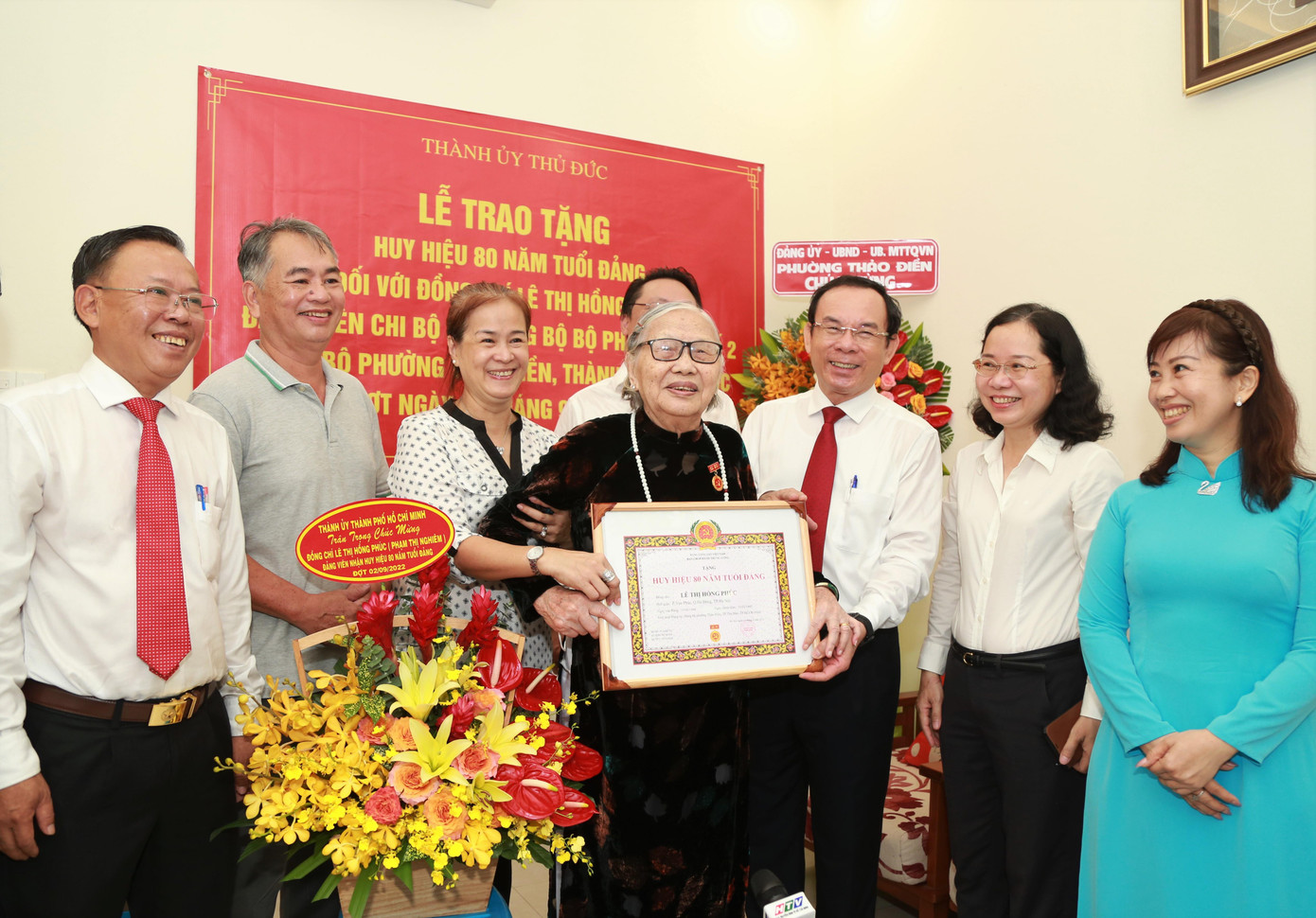 Đảng viên Lê Thị Hồng Phúc và gia đình chụp ảnh lưu niệm cùng lãnh đạo thành phố tại buổi lễ trao tặng.