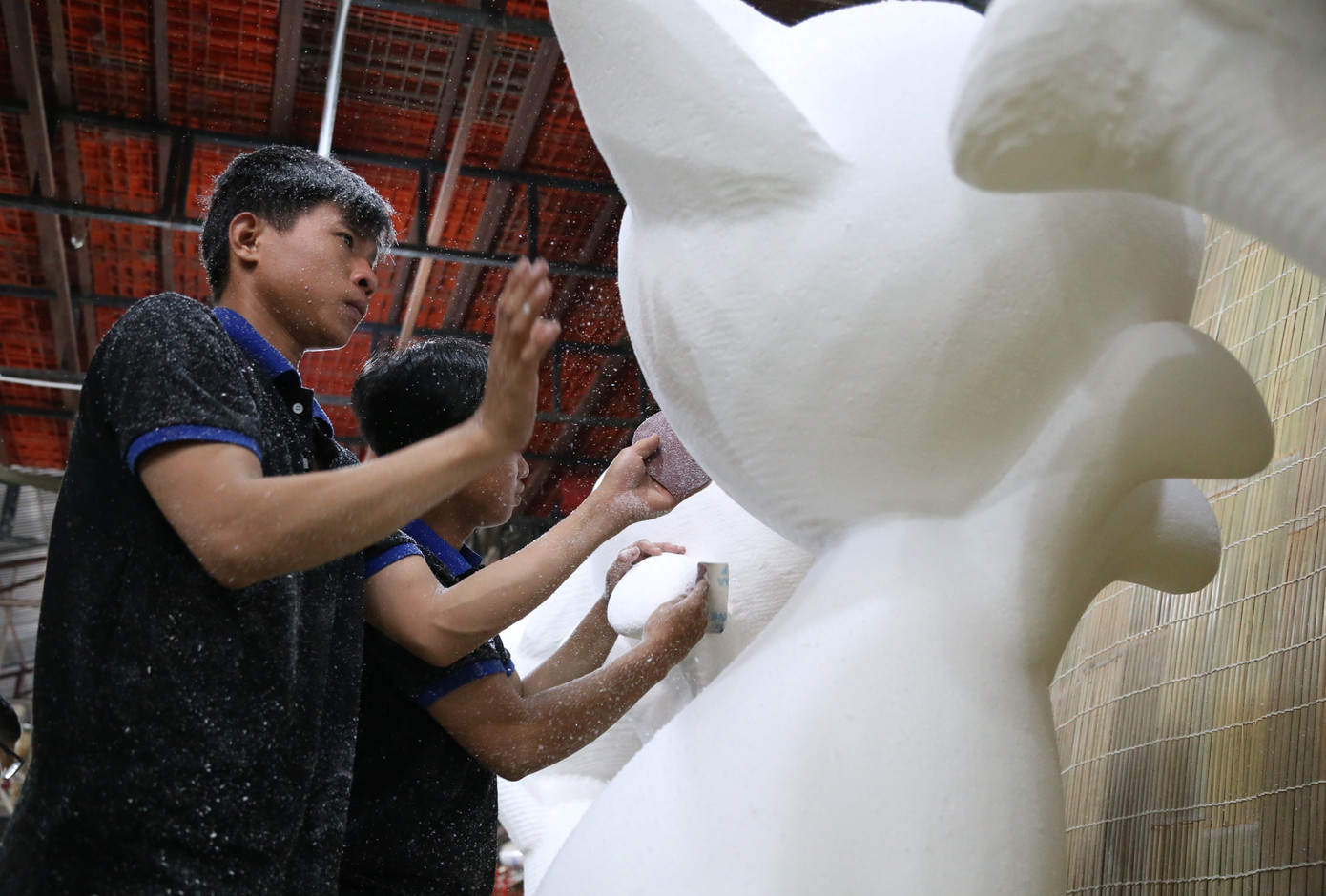 Công nhân mài nhẵn bề mặt trước khi thực hiện phủ keo cũng như các lớp sơn tạo hình cho các linh vật mèo. Nhiều chất liệu thực hiện, thi công linh vật và các tiểu cảnh đảm bảo gần gũi với thiên như: cỏ, mây tre, đất nung…