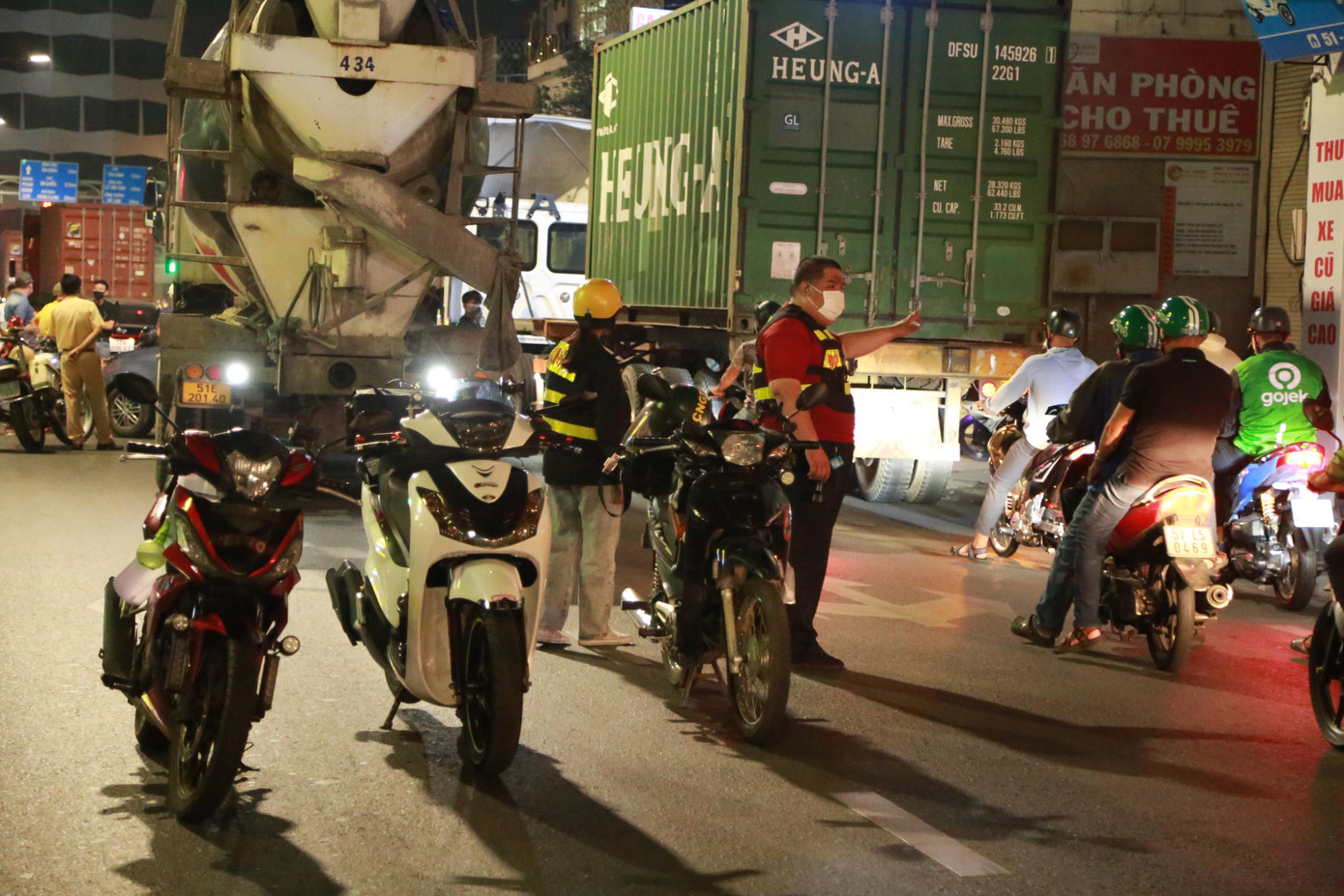 Dù giữa khuya, lượng người lưu thông qua đây khá đông. Các bạn chia nhau hướng dẫn người dân qua hiện trường một cách an toàn.