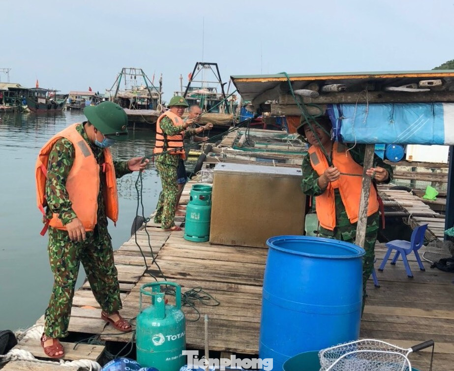 Cán bộ Biên phòng giúp người dân chằng chống chòi canh nuôi trồng thủy sản ven biển.