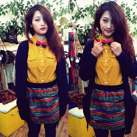 Cô gái này có sự kết hợp vừa nữ tính, vừa cá tính khi diện chân váy họa tiết và áo sơ-mi cotton vàng nghệ