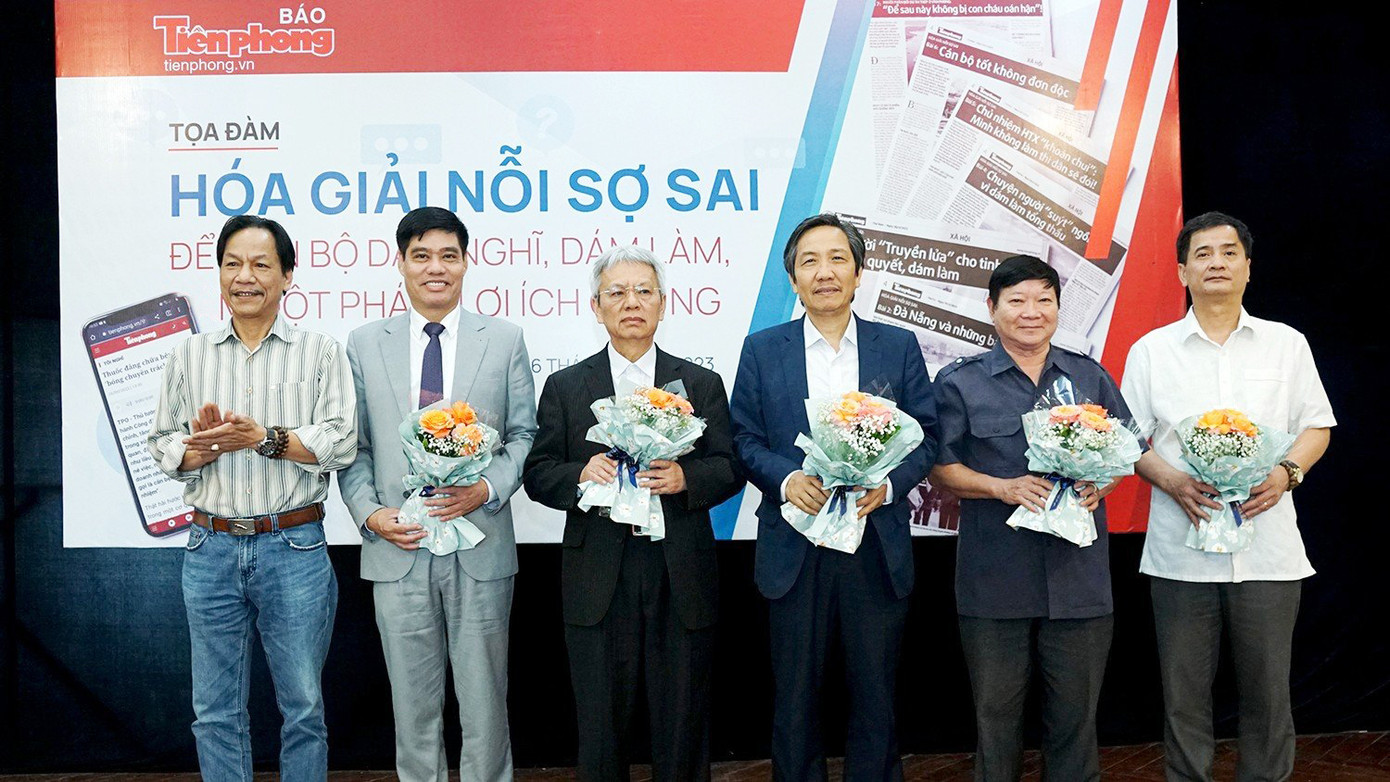 Nhà báo Lê Minh Toản - Phó Tổng Biên tập Báo Tiền Phong (ngoài cùng bên trái) tặng hoa các vị khách mời dự tọa đàm.