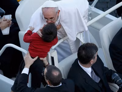 Giáo hoàng hôn một em bé trước lễ nhậm chức ngày 19/3. Ảnh: getty images
