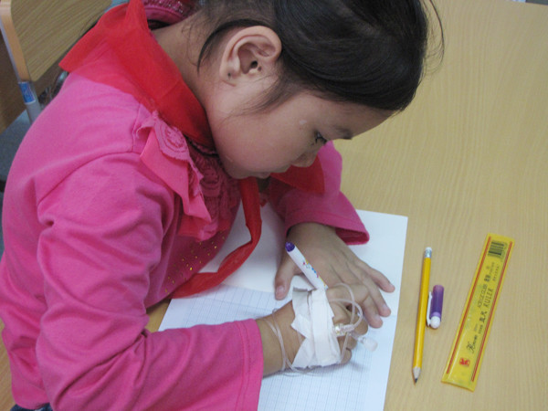 Em Trần Kim Anh (Mỹ Đức- Hà Nội)bị u cổ thận đang viết nắn nót trên vở