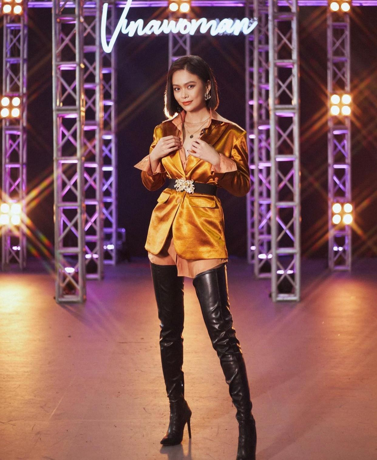 Á hậu Mâu Thuỷ nổi bật với set đồ tông màu vàng đồng kết hợp với boots đen quá đầu gối cá tính.