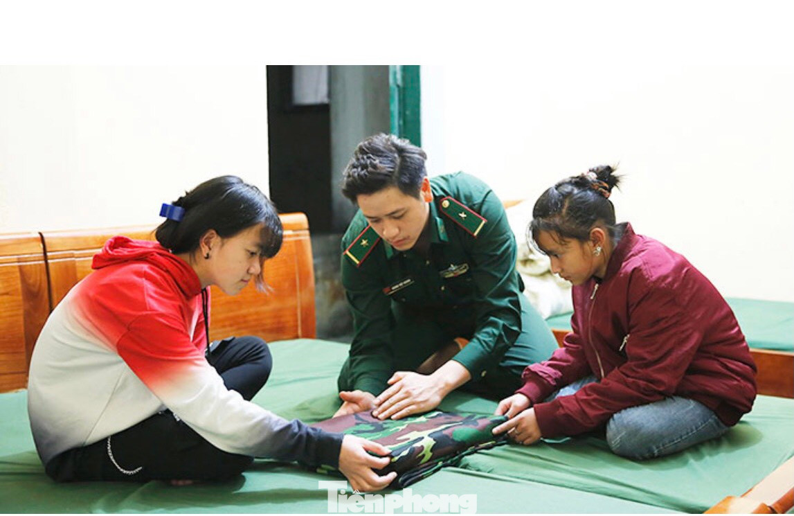 Cán bộ chỉ dẫn cách gập chăn, màn cho các con.