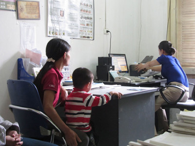 Thủy (bên phải) làm thủ tục cấp thuốc cho bệnh nhân HIV/AIDS. Ảnh: Quang Long