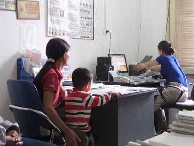 Thủy (bên phải) làm thủ tục cấp thuốc cho bệnh nhân HIV/AIDS. Ảnh: Quang Long