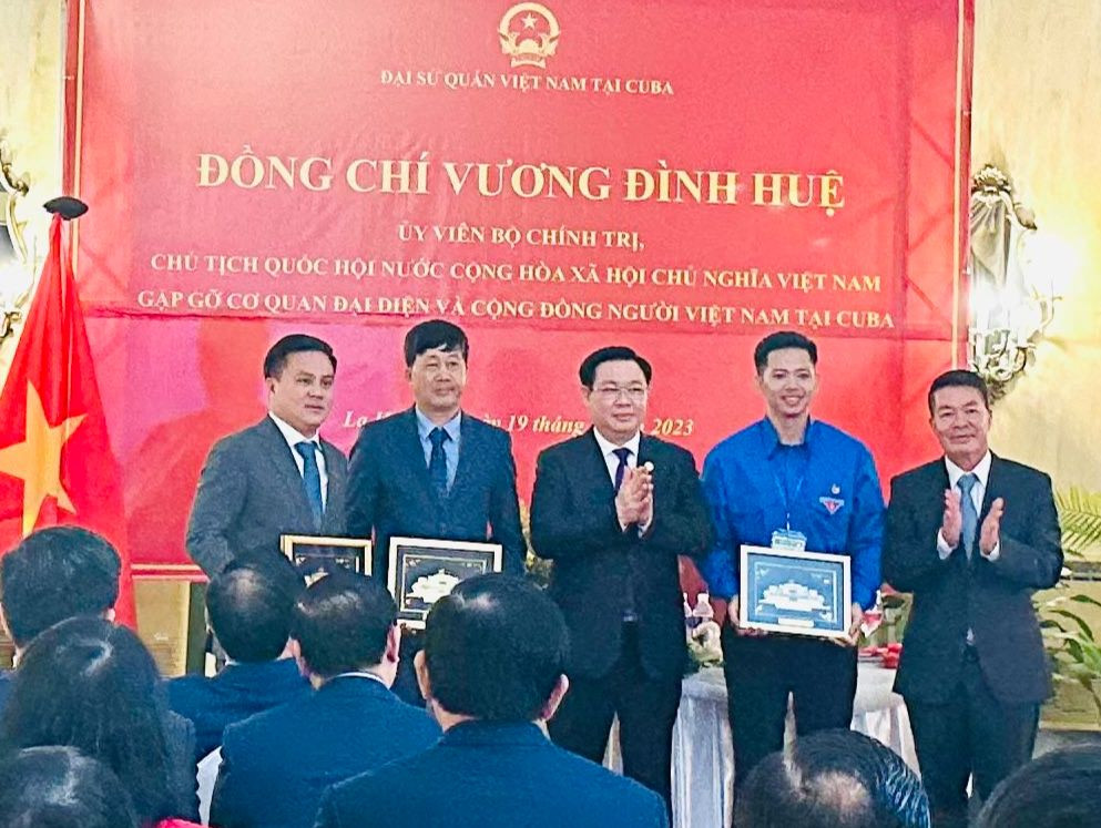 Lê Đức Thắng (thứ hai từ trái sang) cùng đại diện cộng đồng người Việt Nam tại Cuba được Chủ tịch Quốc hội Vương Đình Huệ tặng quà. (Ảnh: Trần Hoài Minh)