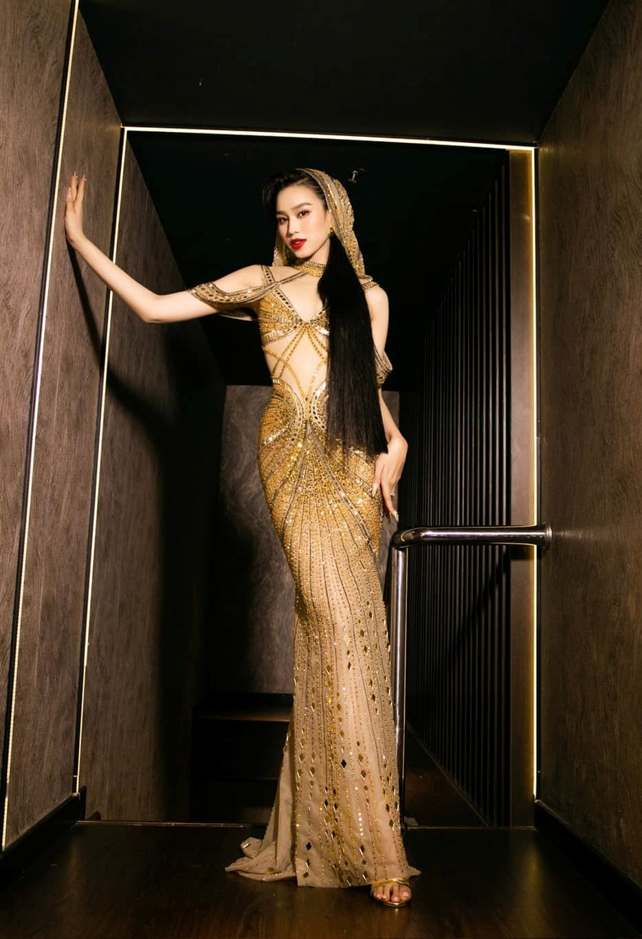 Hoa hậu Đỗ Thị Hà xuất hiện với nhan sắc tựa "nữ thần" trong chiếc váy dạ hội trùm đầu màu vàng gold ôm sát, khoe trọn đường cong cơ thể.