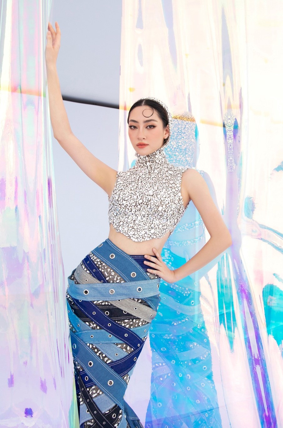 Hoa hậu Lương Thùy Linh diện váy đuôi cá màu xanh, kết hợp chiếc áo trùm đầu lấp lánh.