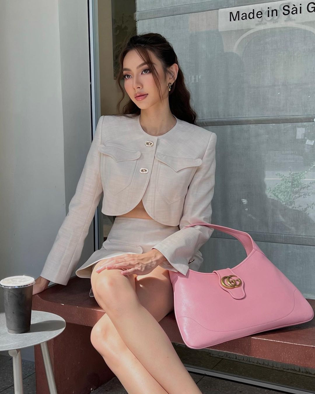 Set đồ màu kem theo phong cách tối giản của Miss Grand International 2021 nữ tính hơn khi được cô kết hợp với chiếc túi xách màu hồng Barbie giá khoảng 55 triệu đồng.