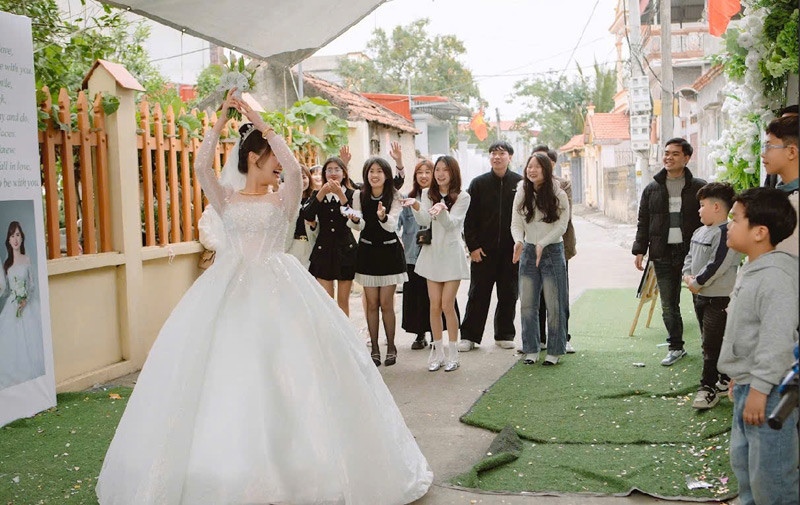 Cô dâu đứng giữa hai nhà tung hoa cưới. Cô dâu đứng giữa hai nhà tung hoa cưới.