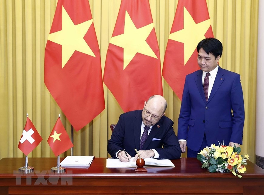 Đại sứ Thụy Sỹ Thomas Gass viết lưu bút tại Phủ Chủ tịch. (Ảnh: Thống Nhất/TTXVN)