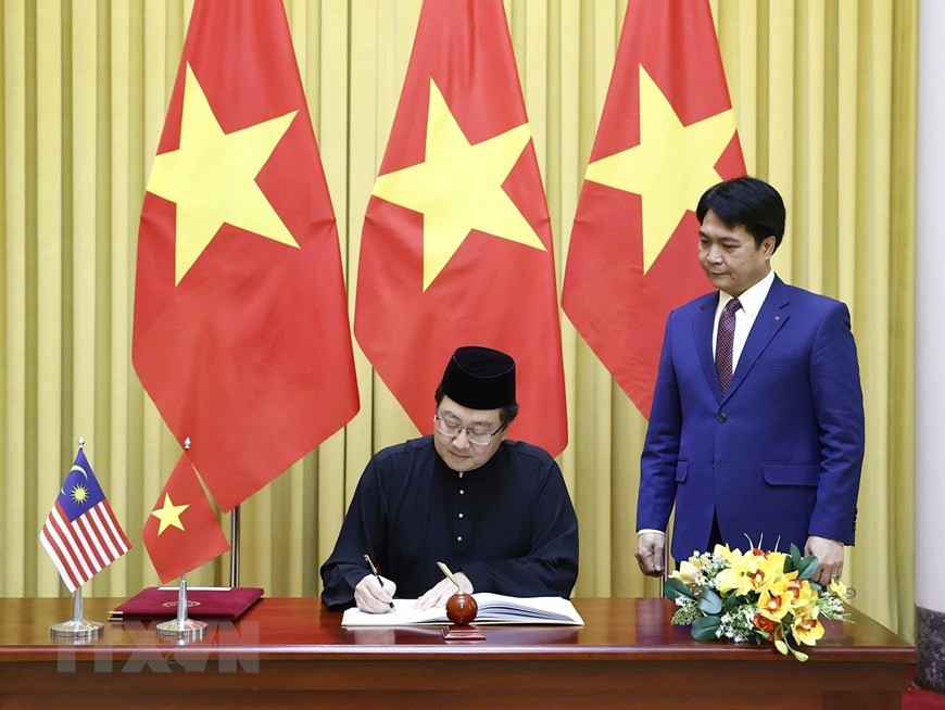 Đại sứ Malaysia Tan Yang Thai viết lưu bút tại Phủ Chủ tịch. (Ảnh: Thống Nhất/TTXVN)