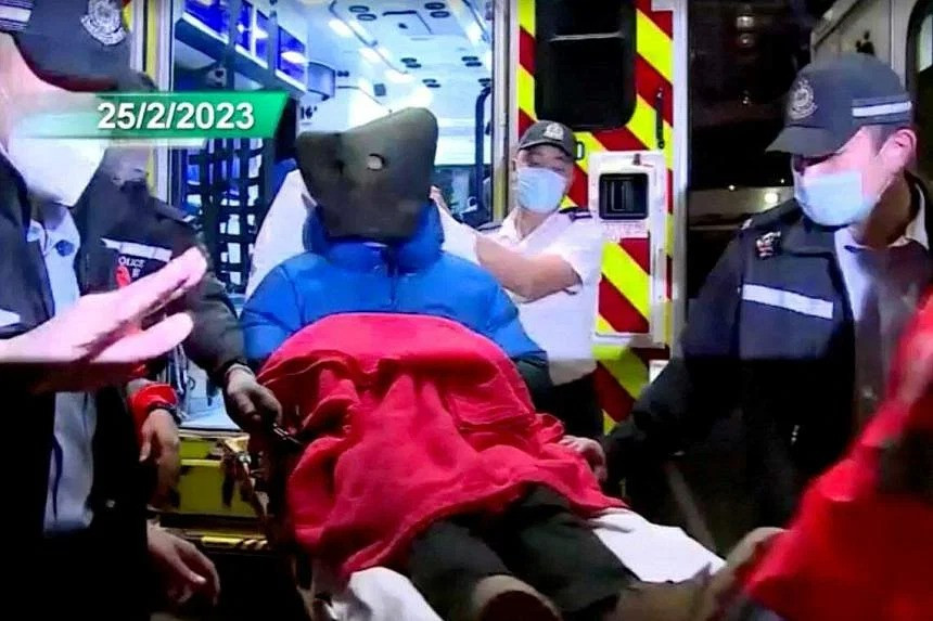 Alex Kwong được đưa đến bệnh viện với một chiếc mũ trùm đầu sau khi bị bắt giữ. Ảnh: Reuters.