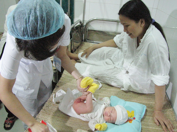 Nhân viên bệnh viện thay tã cho cháu Trường. Ảnh: Lãng Phong.