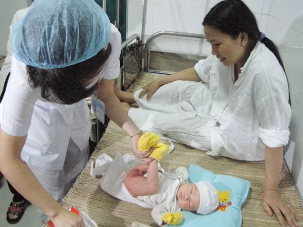 Nhân viên bệnh viện thay tã cho cháu Trường. Ảnh: Lãng Phong.