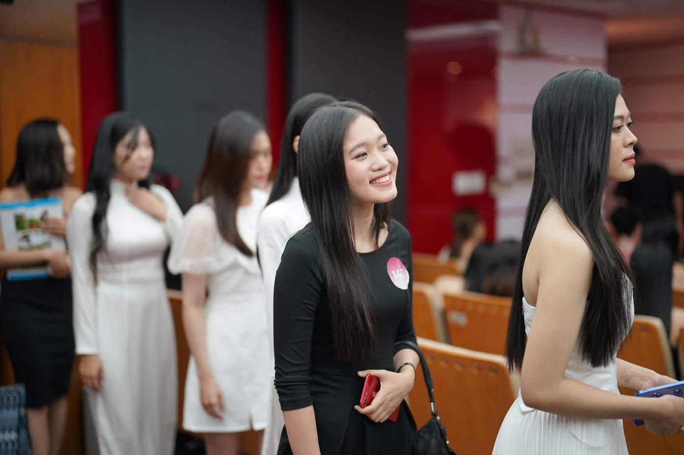 Các cô gái rạng rỡ xếp hàng tiến vào hội trường để nghe ban giám khảo phổ biến những điểm cần lưu ý trước khi vào phỏng vấn kín và đo nhân trắc học.