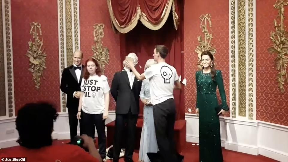 Hai thành viên Just Stop Oil trét bánh kem lên tượng sáp Vua Charles. Ảnh: Daily Mail.
